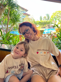 Mum and child sitting by the pool, on holiday, wearing matching shirts