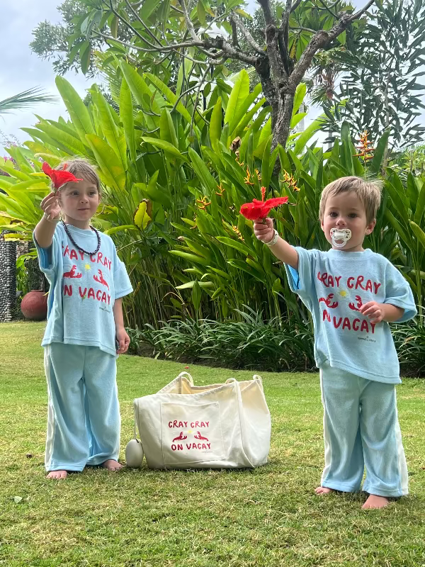 Two children in matching outfits with 'Cray Cray on Vacay' text, holding red flowers in a garden setting.
Tote Bag for Holiday