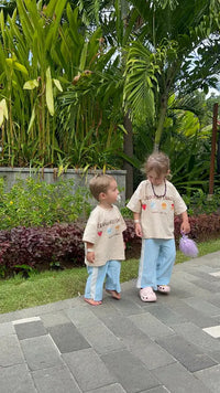 two sibling family children in matching outfits on tropical  holiday