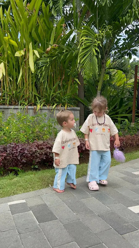 two sibling family children in matching outfits on tropical  holiday