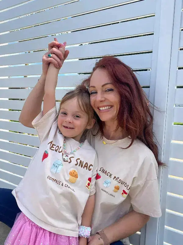 mum and daughter wearing matching t-shirts with graphic designs against a white lattice background