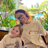 Mum and child sitting by the pool, on holiday, wearing matching shirts