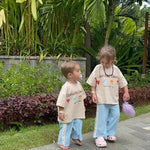 two sibling family children in matching outfits on tropical  holiday