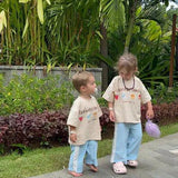 two sibling family children in matching outfits on tropical  holiday