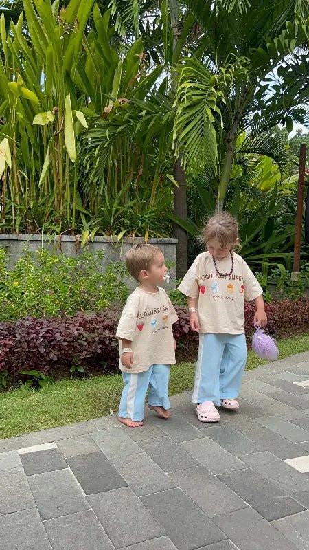 two sibling family children in matching outfits on tropical  holiday