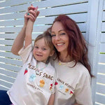 mum and daughter wearing matching t-shirts with graphic designs against a white lattice background