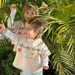 Two sibling children in matching graphic beige t-shirts australia