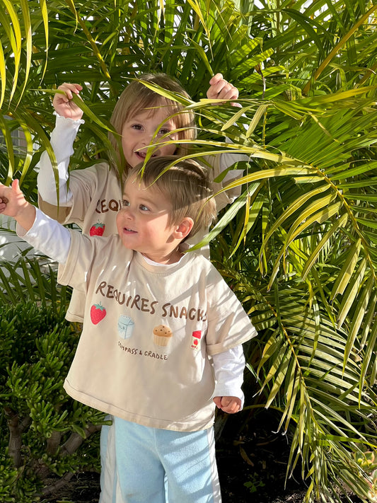 Two sibling children in matching graphic beige t-shirts australia