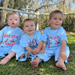 Children sitting together in matching shirts, matching pants in the park for summer 