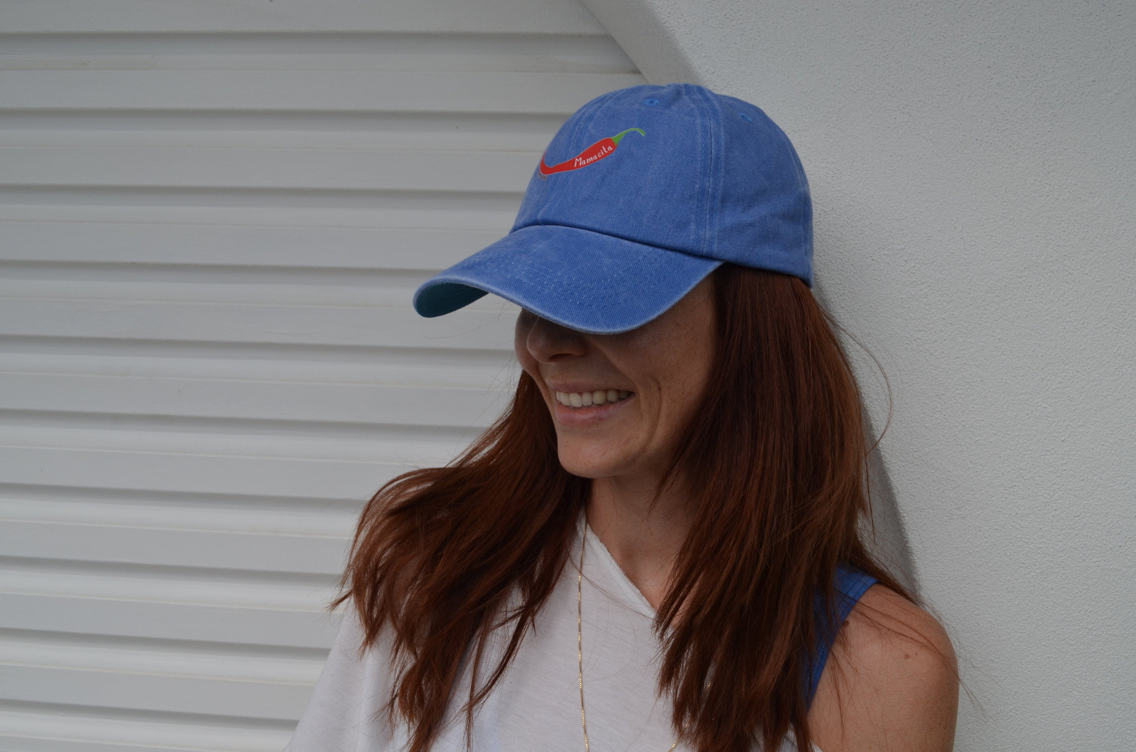 Woman wearing a blue cap with  chili mamacita logo from compass and cradle